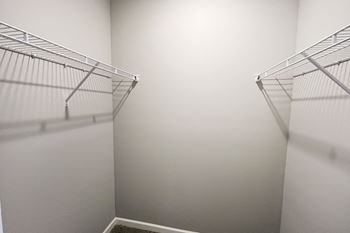an empty closet with two shelves in a room with white walls
